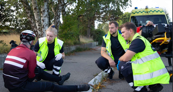 Ambulancebehandler til ser en cykelist som er faldet